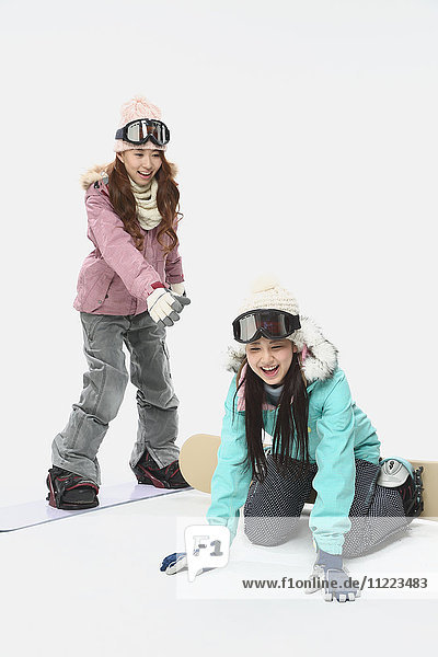 Young Japanese women wearing snowboard wear on white background