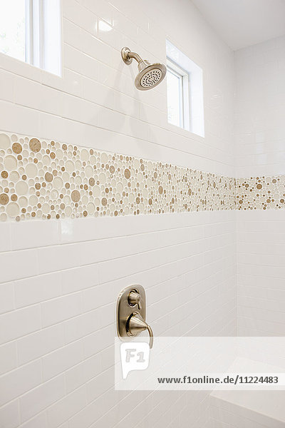 Dusche mit weiß gefliester Wand im häuslichen Badezimmer