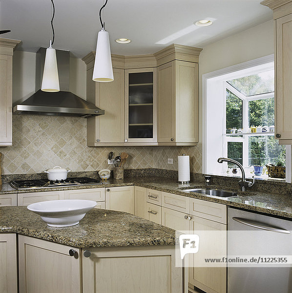 Granitarbeitsplatten in der Küche mit dreieckigem Arbeitsbereich  Fliesenspiegel mit Hängeleuchten  Fenstergewächshaus