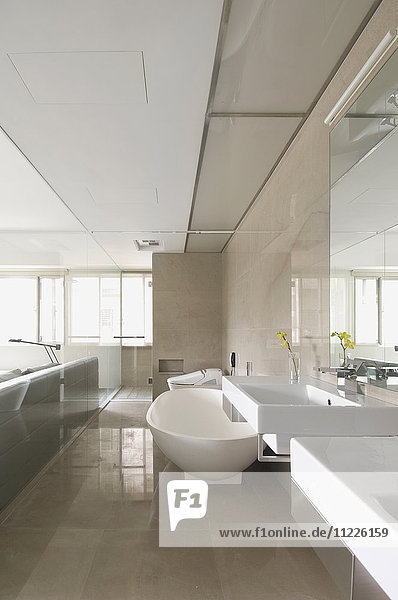 Modernes Badezimmer mit Glaswand als Trennung zum Schlafzimmer