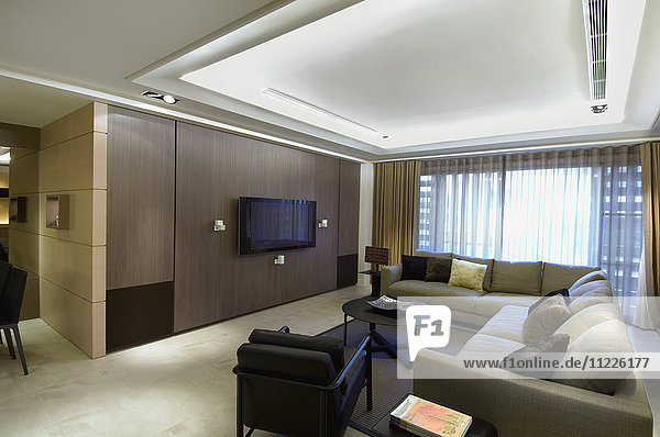 Modernes Wohnzimmer mit Sektionssofa und Flachbildfernseher