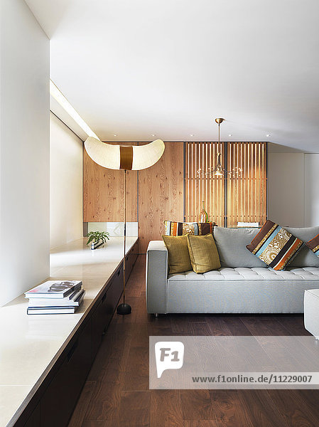 Wohnzimmer mit grauem Sofa und Parkettboden in einer modernen Wohnung