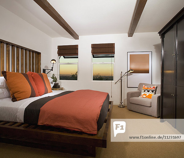 Gemütliches Schlafzimmer mit terrakottafarbener Bettdecke