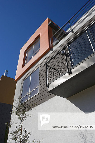 Außenansicht eines modernen Hauses mit orangefarbener Wand und Balkon