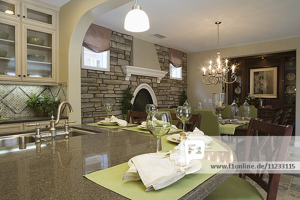 Küche mit Frühstücksbar und Esszimmer mit Steinwand