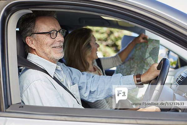 Senior man in car  woman holding map