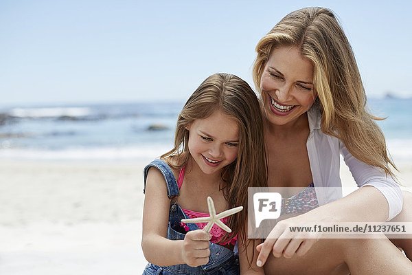 Mother with daughter holding starfish