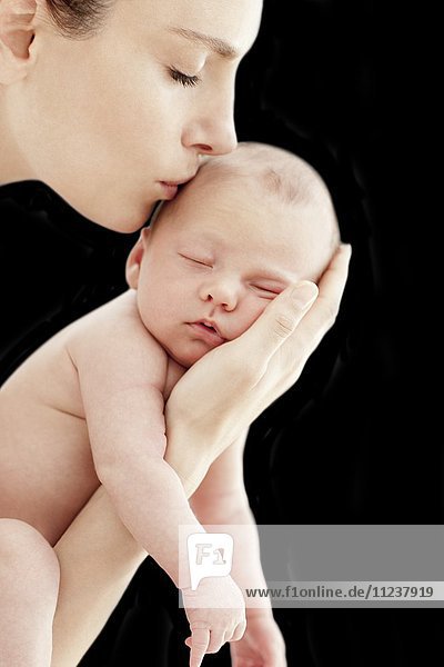 Mutter küsst neugeborenes Baby