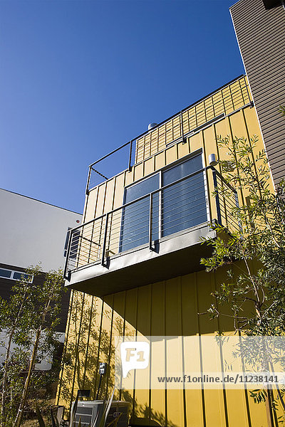 Außendetail eines modernen Hauses und eines Balkons mit gelber Wand