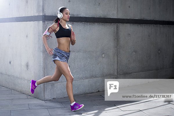 Woman wearing headphones running