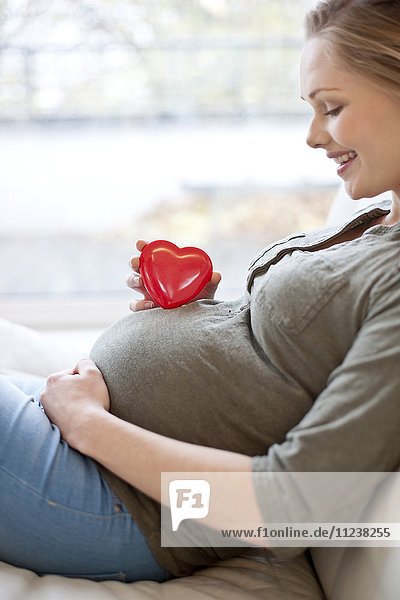 Pregnant woman with heart shape on tummy
