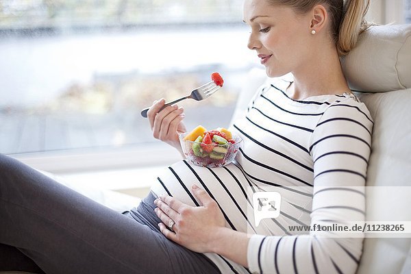 Schwangere Frau isst Obstsalat