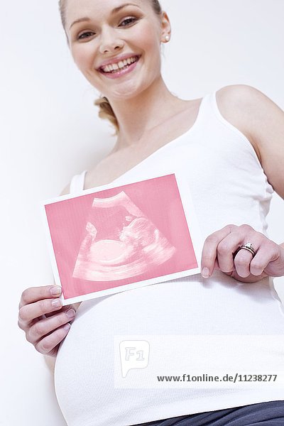 Schwangere Frau hält rosa Baby-Scan