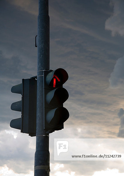 Red traffic light on dark cloudy day