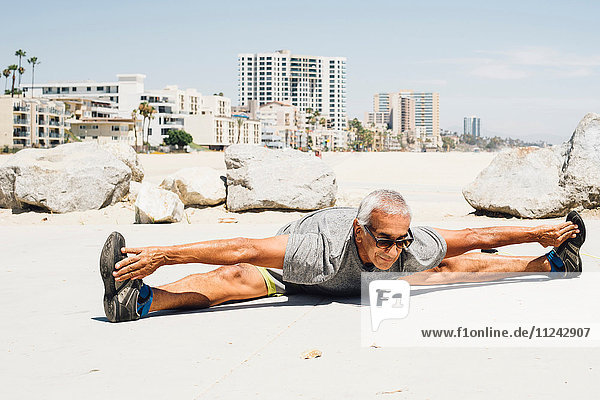 Älterer Mann  am Strand trainierend  Stretching  Long Beach  Kalifornien  USA