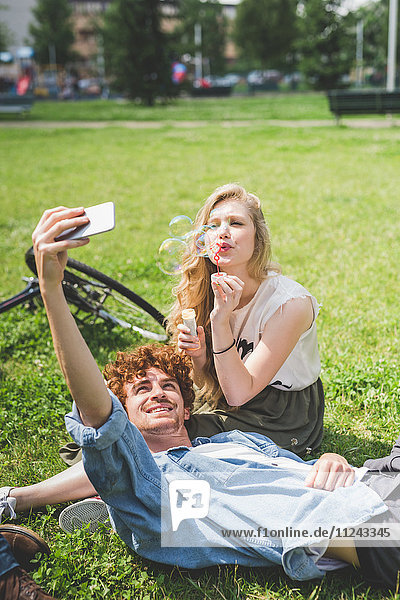 Paar nimmt Selfie im Park mit.