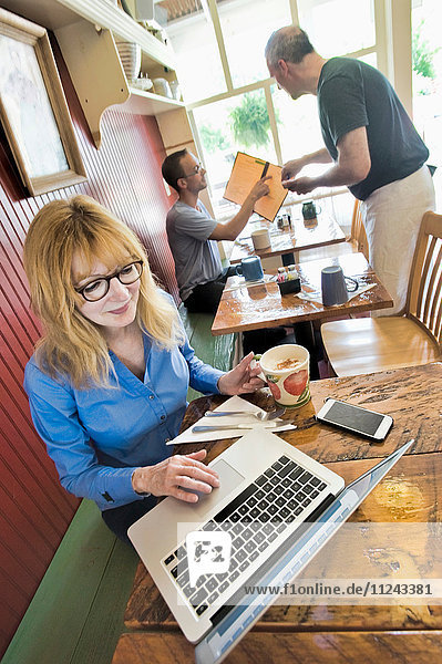 Frau benutzt Laptop im Café