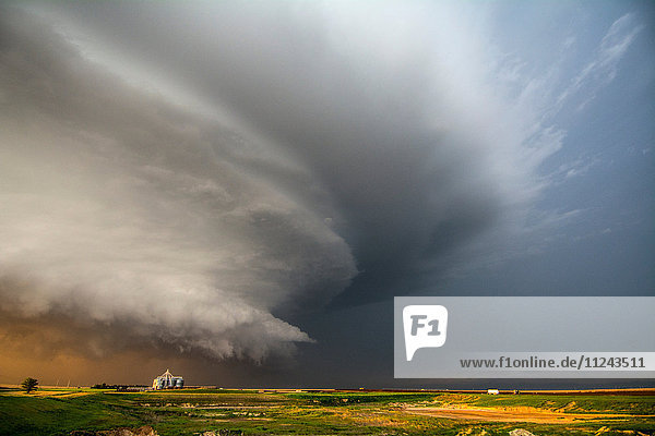 Ein Tornado produziert ein Superzellen-Gewitter  das bei Sonnenuntergang in der Nähe von Leoti  Kansas  über Ranchland wütet