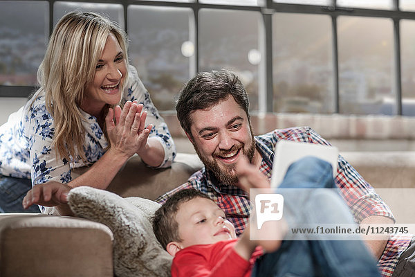 Eltern und Sohn mit digitalem Tablett zu Hause