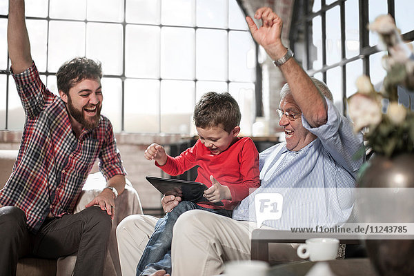 Three generation family using digital tablet at home