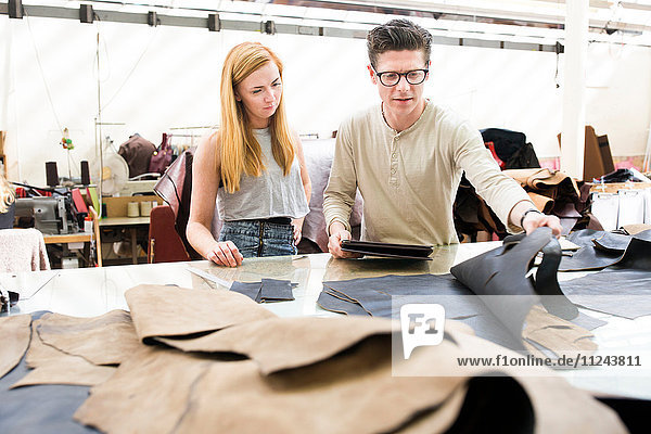 Männliche und weibliche Kollegen arbeiten bei Lederjackenherstellern zusammen