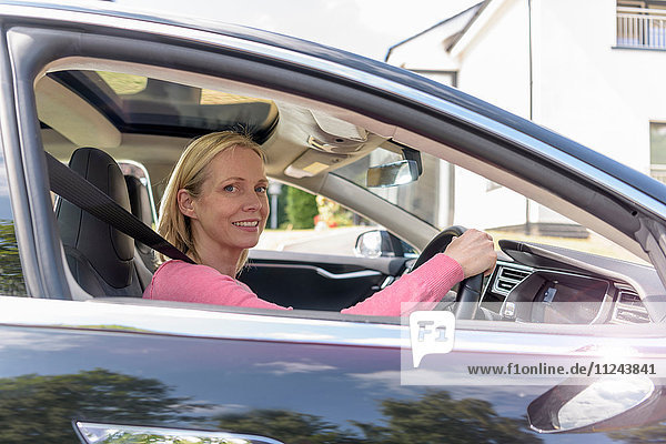 Porträt einer Frau am Steuer eines Elektroautos