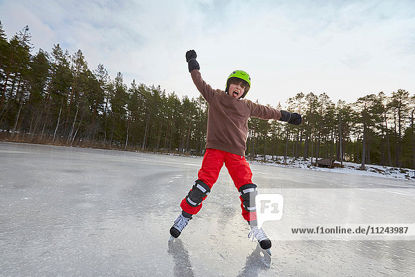 Junge balanciert beim Schlittschuhlaufen auf gefrorenem See  Gavle  Schweden