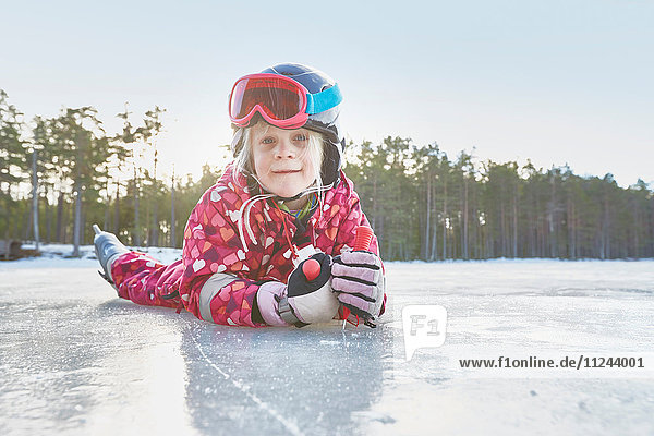 Portrait of girl lying on her front on frozen lake  Gavle  Sweden