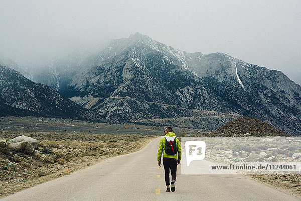 Rear view of hiker on road by mountains  Lone Pine  California  USA