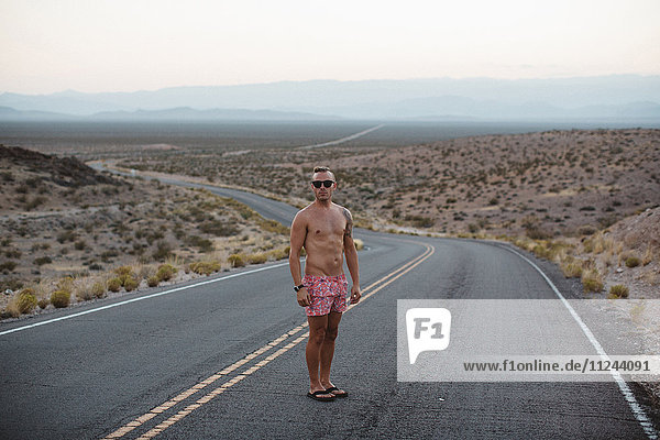 Man wearing shorts and flip flops standing in road  Valley of Fire  Nevada  USA