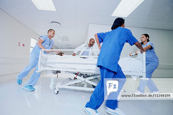 Doctor and medical running with patient bed in hospital emergency