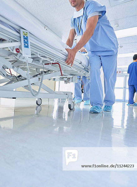 Zwei Sanitäter schieben dringend Krankenhausbett den Korridor entlang
