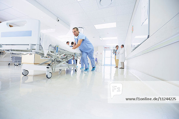 Mediziner schieben Krankenhausbett dringend den Korridor entlang
