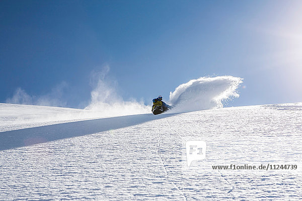 Mann fährt mit dem Snowboard den steilen Berg hinunter  Trient  Schweizer Alpen  Schweiz