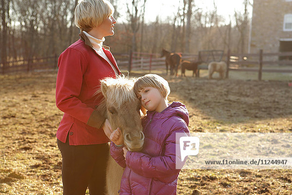 Mutter und Tochter im Freien  stehend mit Pony