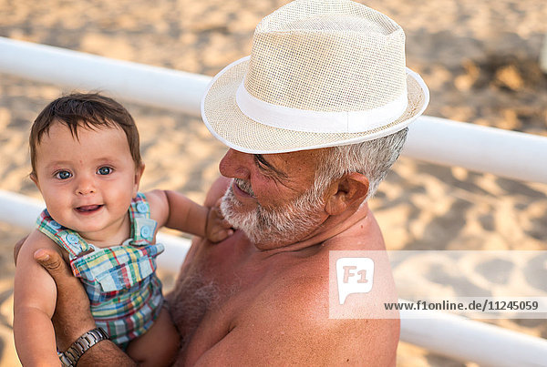 Großvater hält lächelnden kleinen Jungen