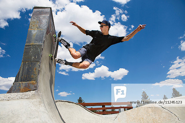 Young man skateboarding in skate park ramp  Mammoth Lakes  California  USA