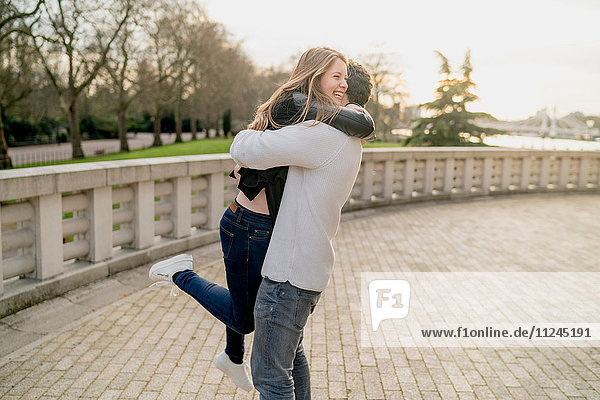 Romantischer junger Mann umarmt Freundin im Battersea Park  London  Großbritannien