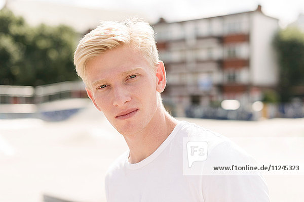 Porträt eines blonden jungen männlichen Skateboardfahrers im Skatepark