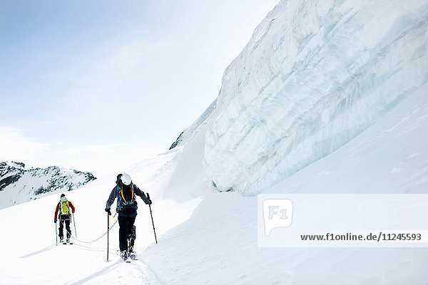 Rückansicht von Bergsteigern beim Skitourengehen auf schneebedecktem Berg  Saas Fee  Schweiz