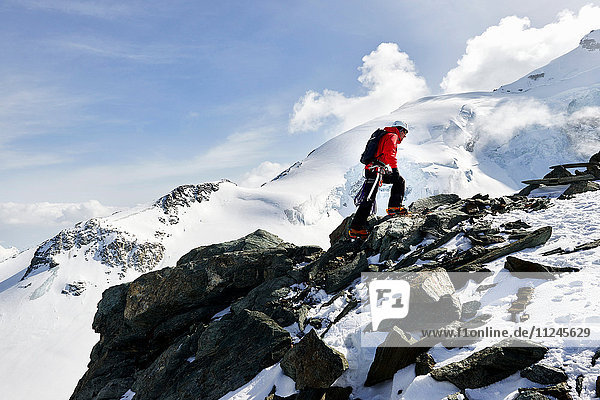 Mann besteigt schneebedeckten Berg  Saas Fee  Schweiz