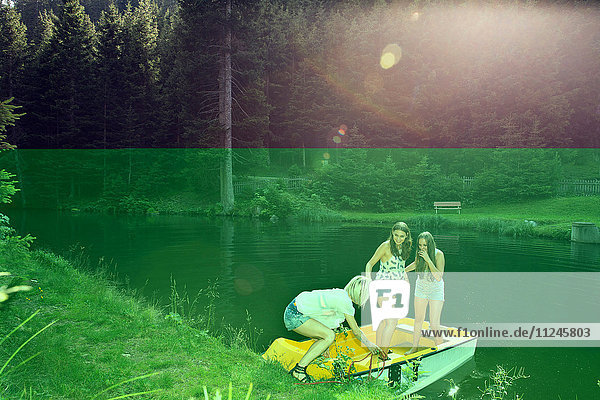 Drei erwachsene Freundinnen starten Ruderboot auf dem See  Sattelbergalm  Tirol  Österreich