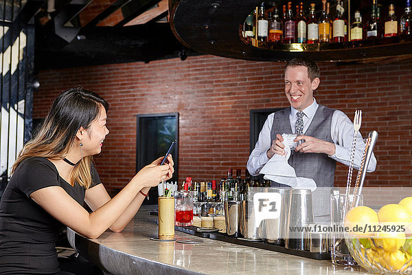 Woman in bar talking with bartender