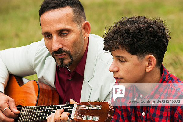 Vater und Sohn im Freien  Vater spielt Gitarre