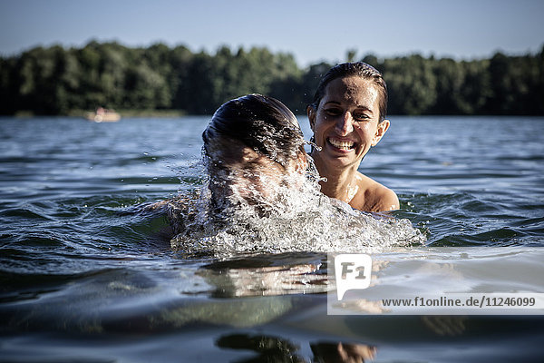Couple splashing in water  smiling  Berlin  Germany