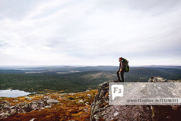 Wanderer geniesst Aussicht auf die Klippen  Keimiotunturi  Lappland  Finnland