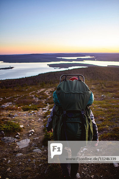 Wanderer genießt Sonnenuntergang am See  Keimiotunturi  Lappland  Finnland