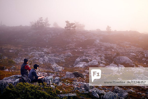 Hikers relaxing with coffee on rocky field Sarkitunturi Lapland Finland