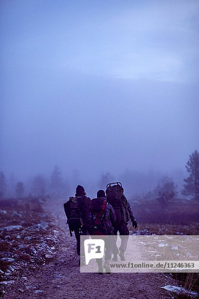 Wanderer durchqueren felsiges Feld in der Dämmerung  Sarkitunturi  Lappland  Finnland