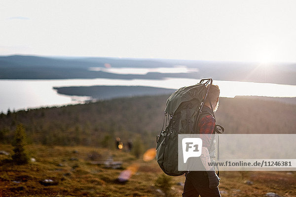 Wanderer durchquert Feld am See  Keimiotunturi  Lappland  Finnland